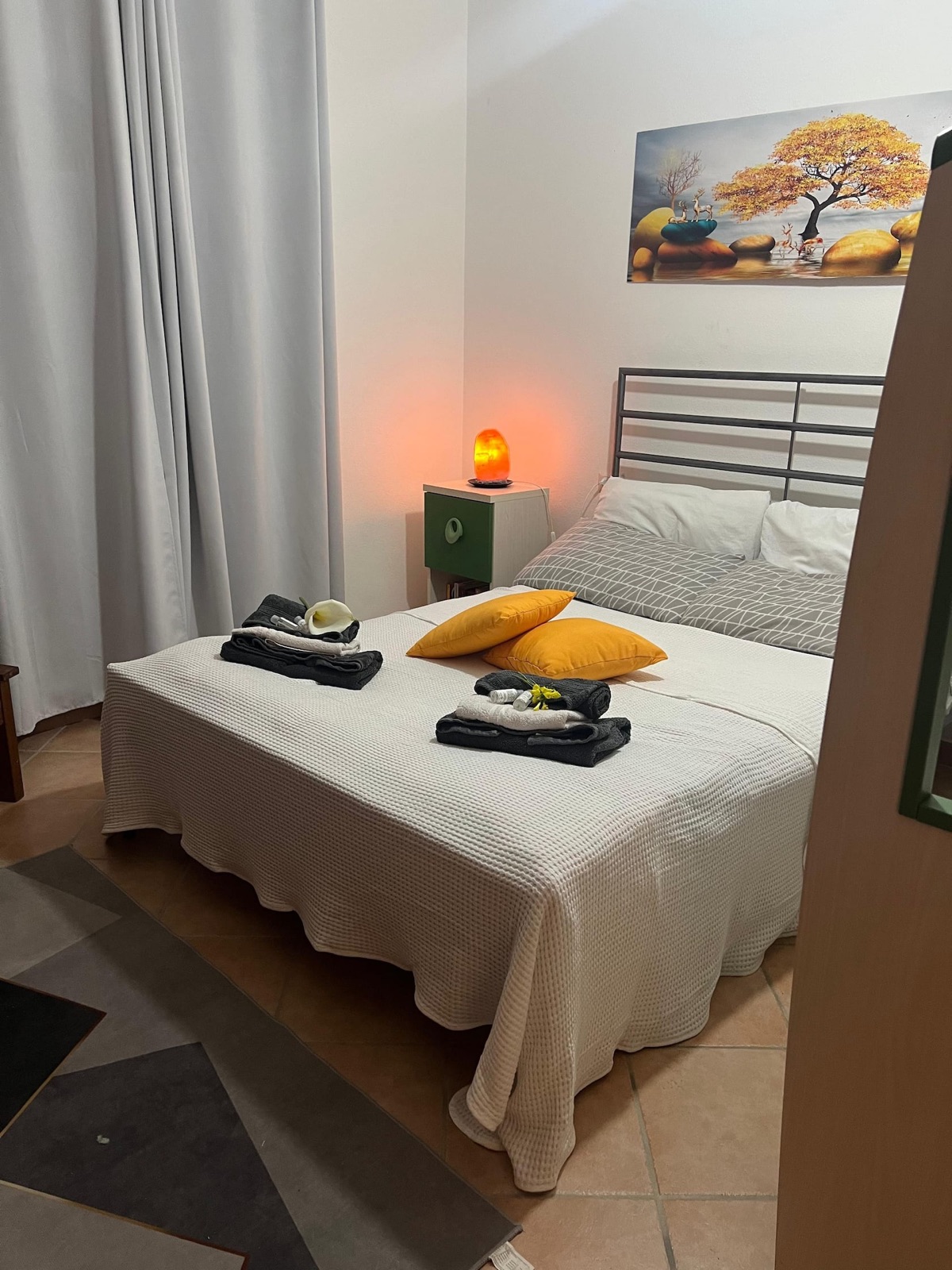 Il letto matrimoniale della camera principale, con lampada di sale