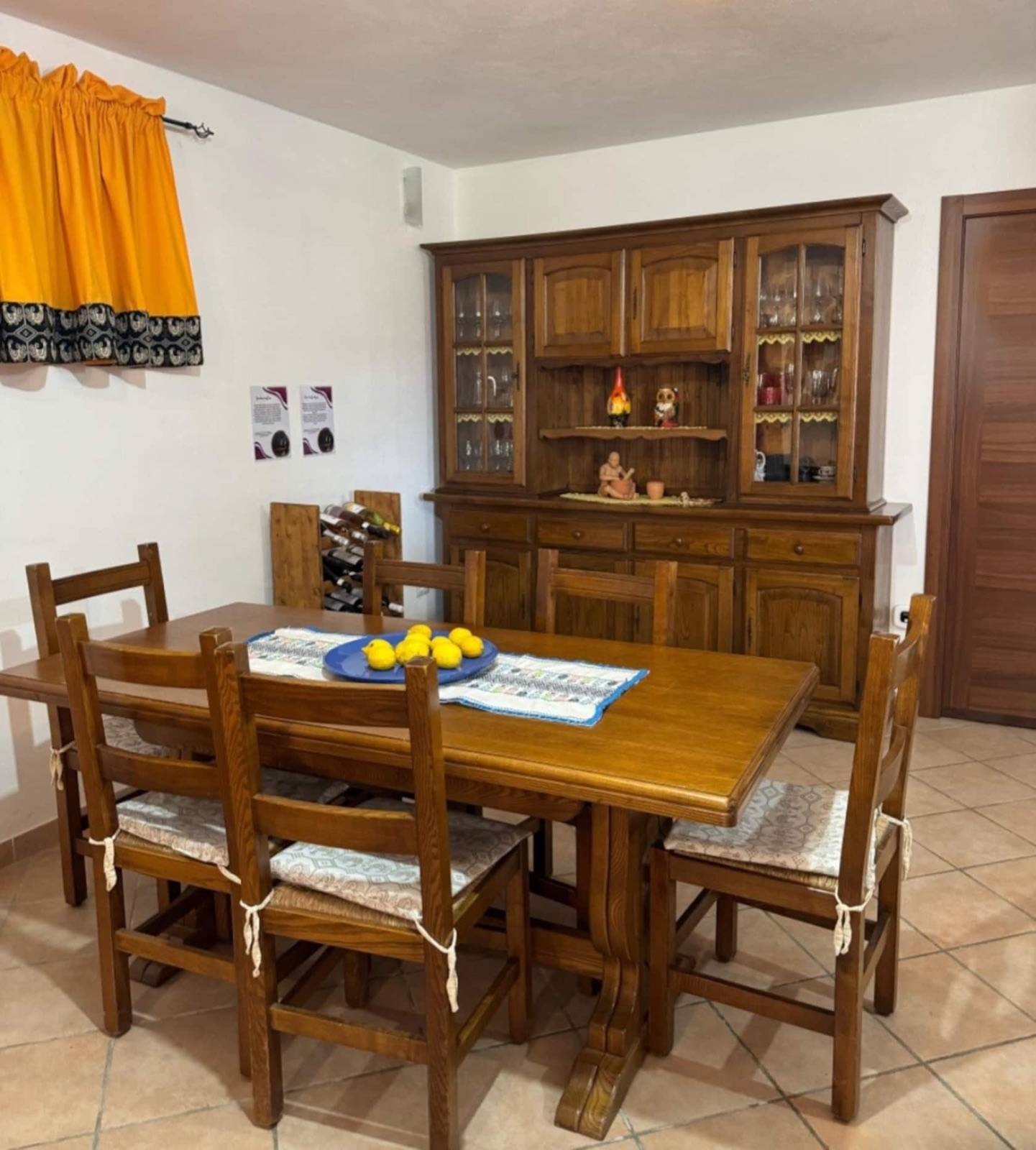 Zona pranzo con tavolo in legno per sei persone e credenza